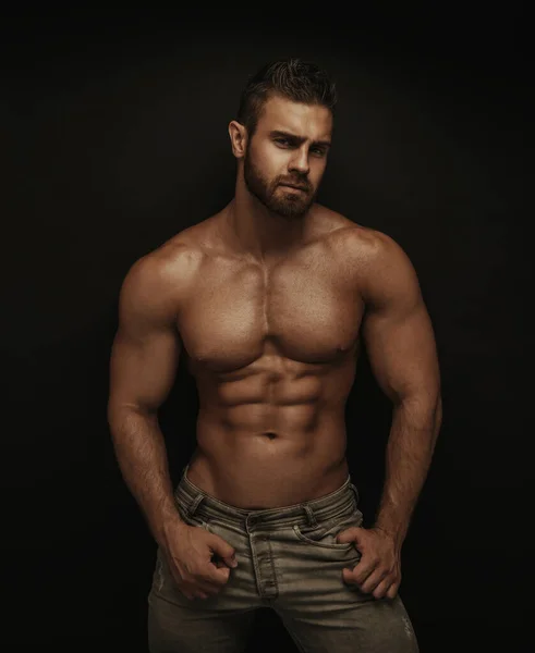 Koyu arkaplanda duran fitness erkek modeli