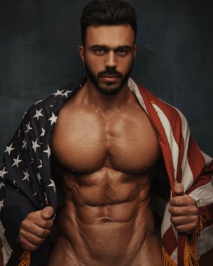 Amerikan bayrağı taşıyan yakışıklı çıplak vücut geliştirici.