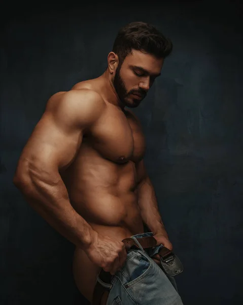 Hunk adam pantolonunu giyiyor.