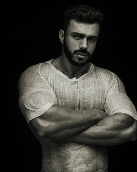 Kollarını kavuşturan yakışıklı erkek fitness modelinin portresi