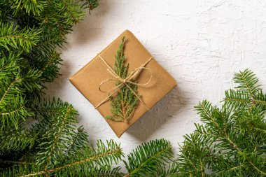 Çam dalları arasında paketlenmiş Noel hediyesi, üst manzara. Metin için alanı kopyala.