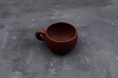 Seramik fincan ve çaydanlık masanın üstünde.