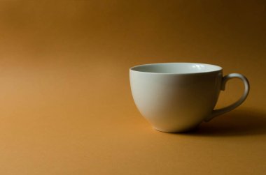 Seramik fincan ve çaydanlık masanın üstünde.