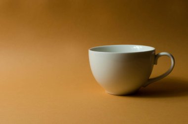 Seramik fincan ve çaydanlık masanın üstünde.