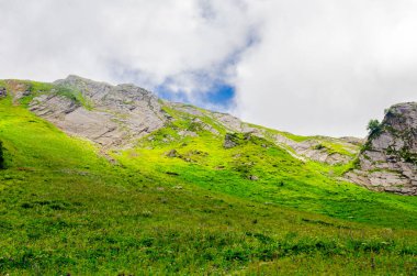 Yazın dağ zirveleri güneşli bir günde bulutlarla birlikte.