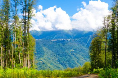 Yazın güneşli bir günde gökyüzünde bulutlarla zengin dağ manzarası. Yüksek kalite fotoğraf