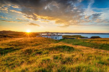 Dramatic sunset over the old coastguard cottages at Arnish Point on the entrance to Stornoway harbour on the Ilse of Lewis in the Western Isles of Scotland clipart