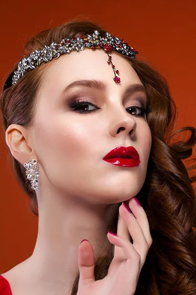 Kırmızı elbiseli güzellik kadın kırmızı bir arka plan. Kırmızı dudaklar ve çivi.