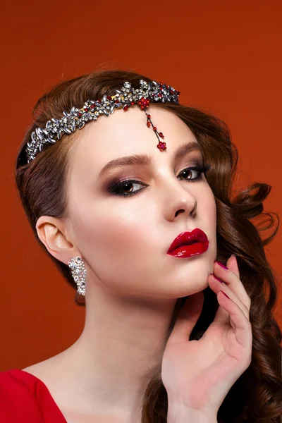 Kırmızı elbiseli güzellik kadın kırmızı bir arka plan. Kırmızı dudaklar ve çivi.