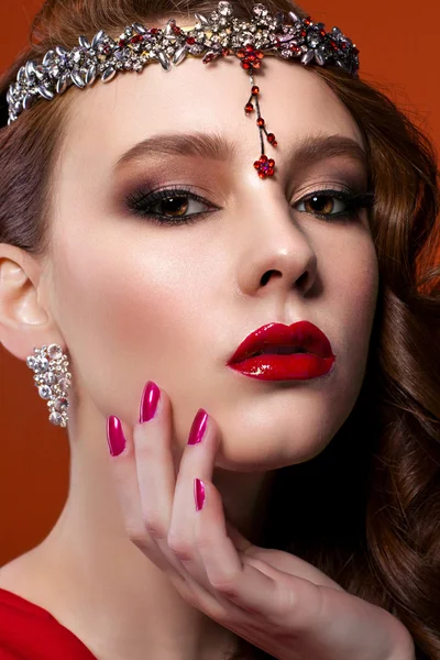 Kırmızı elbiseli güzellik kadın kırmızı bir arka plan. Kırmızı dudaklar ve çivi.
