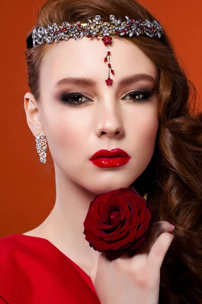 Wanita cantik dengan mawar merah. Gambar wajah gadis fashion dengan warna merah — Stok Foto