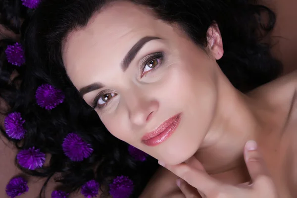 Portrait of beautiful middle aged woman with wild flowers — Stock Photo, Image