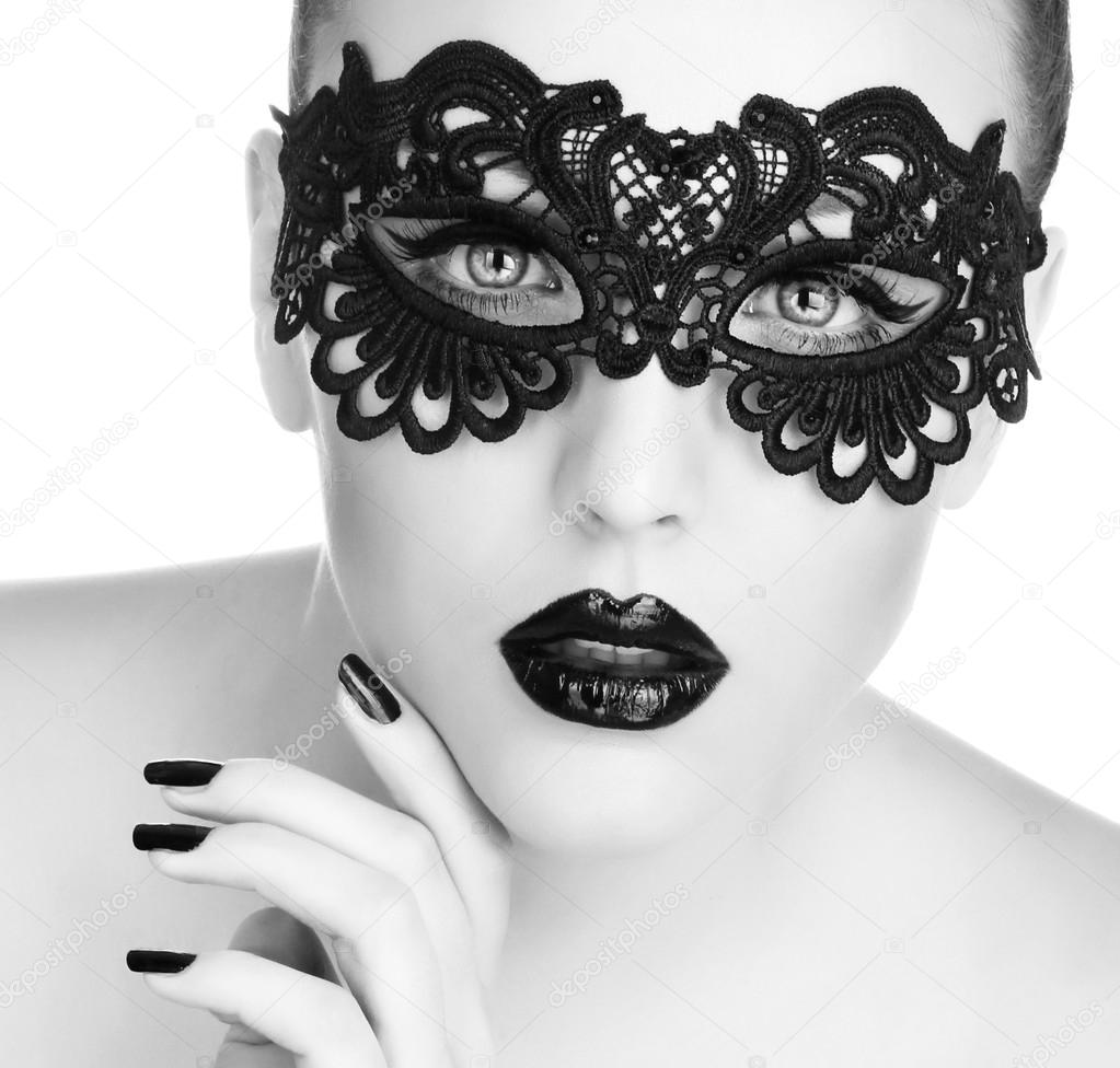 Beautiful Woman with Black Lace mask over her Eyes.  Black Manicure and Lipstick. Manicure and Makeup. Make up concept. Passion