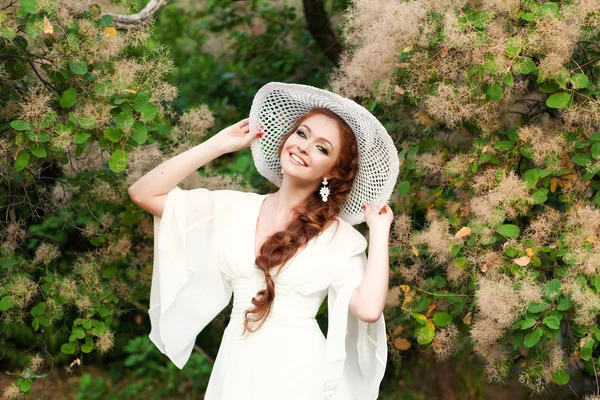 Красивая рыжая девушка в стильной соломенной шляпе — стоковое фото