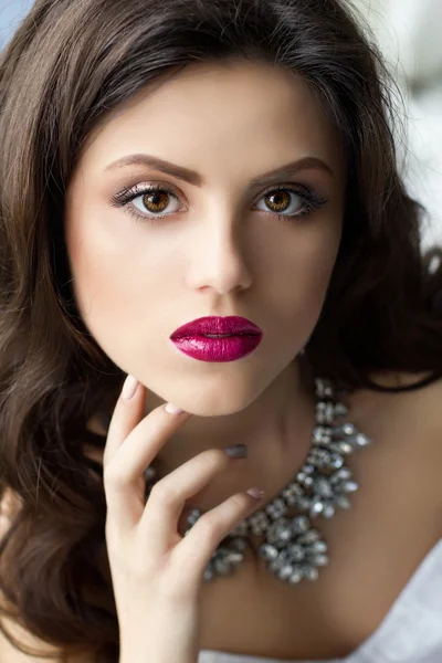 Beautiful long-haired girl in a luxurious and lush dress sitting — Stock Photo, Image