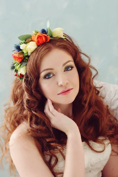 Modern ve şık Kızıl saçlı gelin başında ile bir güzel düğün buket çiçek çelenk içinde bir sandalyede oturan yapısı örme