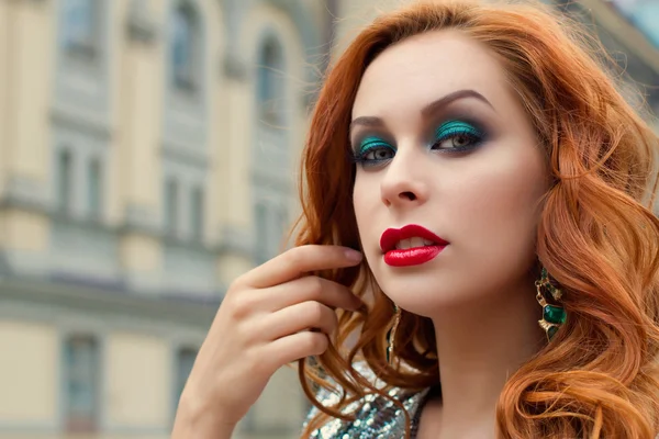 Atractiva chica pelirroja, labios rojos y ojos verdes, pasea por la ciudad, el viento ondeando el pelo. Camina cerca de Kiev Opera House. Imagen tonificada y ruido añadido — Foto de Stock