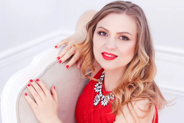 Una mujer glamorosa en vestido rojo sonriendo —  Fotos de Stock