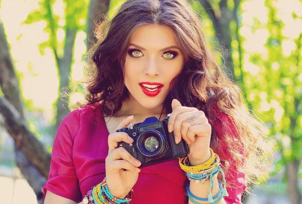 Young beautiful girl photographer with vintage camera in garden. — Stock Photo, Image