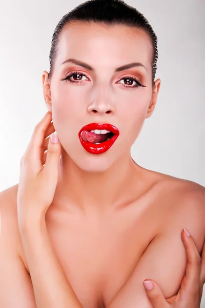 Portrait of a pretty girl with red lips showing her tongue — Stock Photo, Image