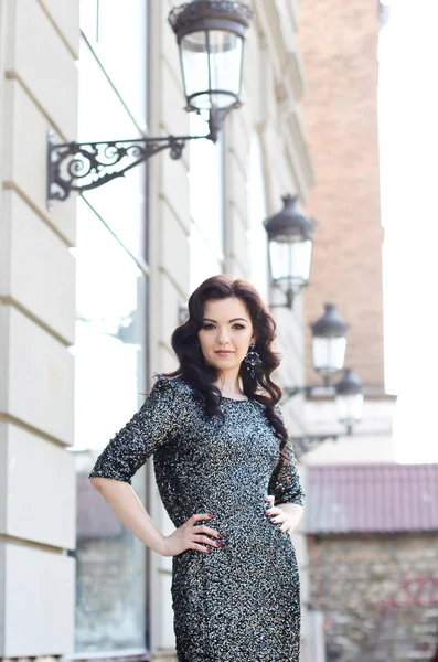 Beautiful young woman in fashionable dress standing on the city — Stock Photo, Image