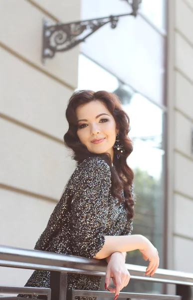 Beautiful young woman in fashionable dress standing on the city — Stock Photo, Image