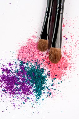 Renkli toz beyaz zemin üzerine makyaj fırçaları. Kalıcı makyaj
