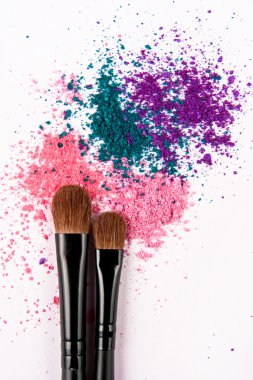 Renkli toz beyaz zemin üzerine makyaj fırçaları. Kalıcı makyaj