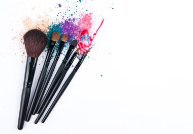 Renkli toz beyaz zemin üzerine makyaj fırçaları. Kalıcı makyaj