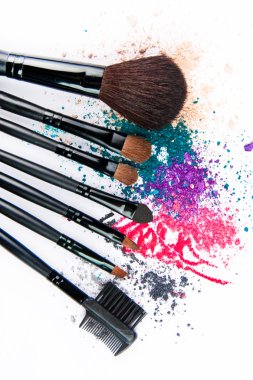 Renkli toz beyaz zemin üzerine makyaj fırçaları. Kalıcı makyaj