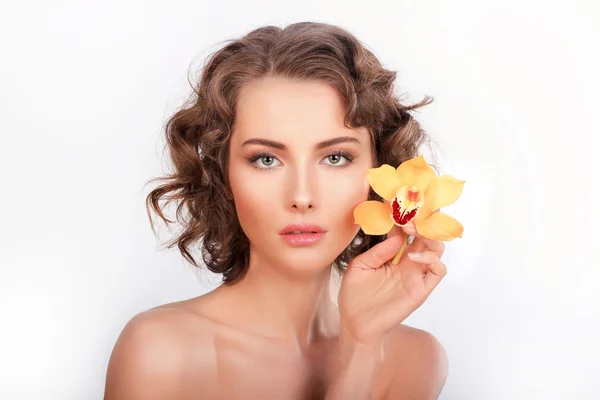 Portret van de schoonheid. Mooie stijlvolle meisje met gele orchidee flowe — Stockfoto