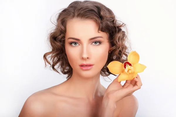 Retrato de beleza. Menina elegante bonita com flowe orquídea amarela — Fotografia de Stock