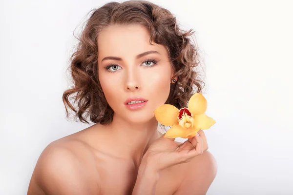 Portret van de schoonheid. Mooie stijlvolle meisje met gele orchidee flowe — Stockfoto