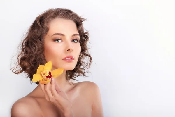 Schönheitsporträt. schöne stilvolle Mädchen mit gelben Orchidee flowe — Stockfoto