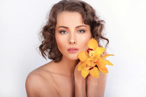 Portret van de schoonheid. Mooie stijlvolle meisje met gele orchidee flowe — Stockfoto