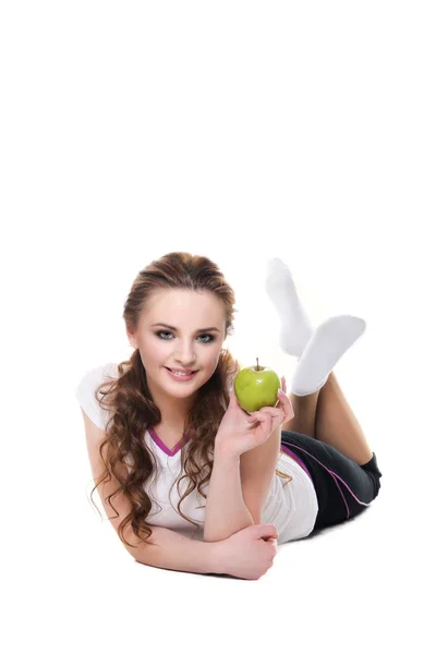 Niña acostada sobre blanco y sosteniendo una manzana - Aislada sobre un blanco — Foto de Stock