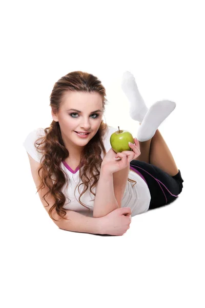 Girl lying on white  and holding an Apple - Isolated on a white — Stock Photo, Image