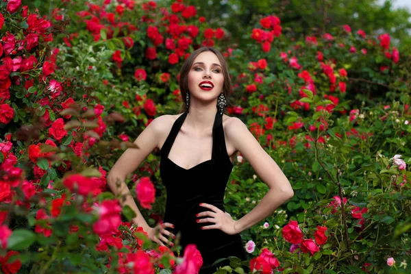 Portrét krásné mladé ženy v růžové zahradě, jaro ti — Stock fotografie