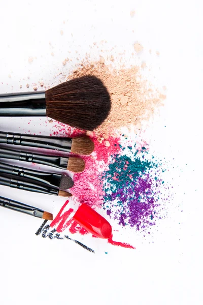 Renkli toz beyaz zemin üzerine makyaj fırçaları. Kalıcı makyaj