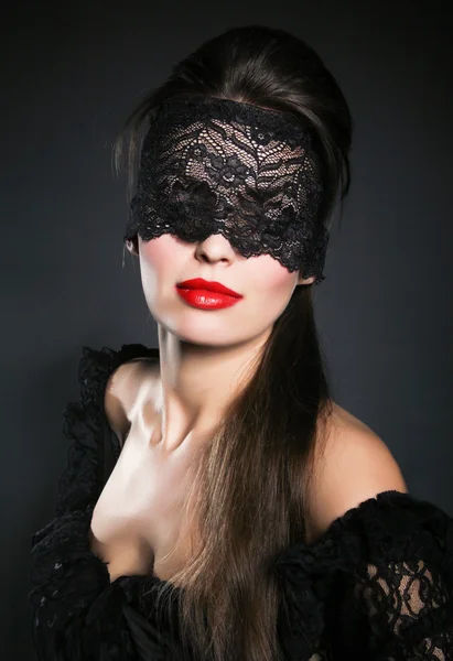 Mulher bonita com máscara de renda preta sobre seu olho — Fotografia de Stock