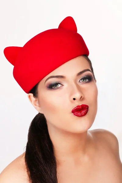 Charming and flirting girl in a funny red hat, the image of a pl — Stock Photo, Image