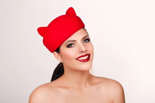 Charming and flirting girl in a funny red hat, the image of a pl — Stock Photo, Image