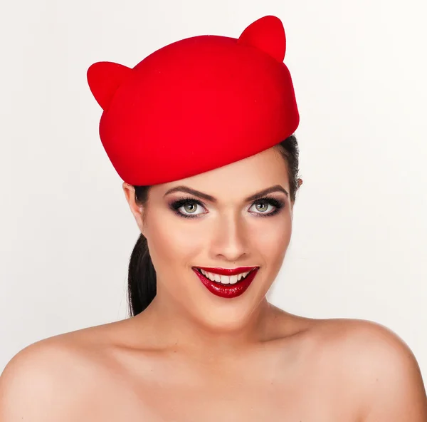 Charming and flirting girl in a funny red hat, the image of a pl — Stock Photo, Image