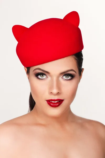 Charmante und flirtende Mädchen mit einem lustigen roten Hut, das Bild eines pl — Stockfoto