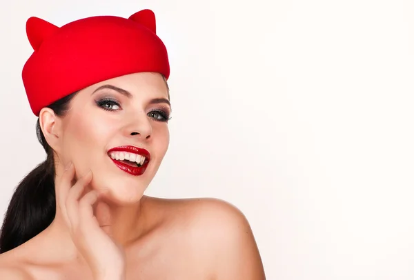 Charming and flirting girl in a funny red hat, the image of a pl — Stock Photo, Image