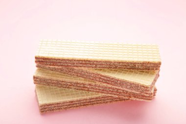 Pembe arka planda lezzetli gofret çubukları. Tatlı yemek. Üst görünüm