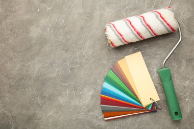 Boya fırçası ve gri beton arka planda renk paleti rehberi. Üst görünüm.