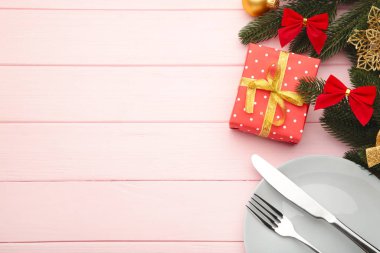 Noel yemeğinin arka planında pembe süslemeler var.