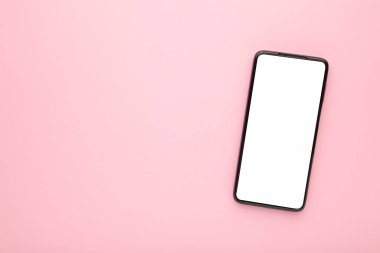 Pembe arka planda boş ekranı olan siyah cep telefonu. Üst görünüm.
