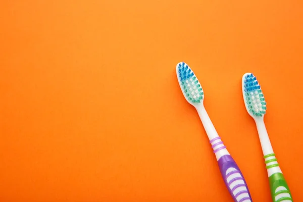 Dos Cepillos Dientes Sobre Fondo Naranja Con Espacio Para Copiar —  Fotos de Stock